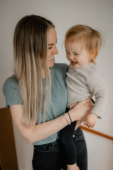 Renée Jordan, lead educator, holding a laughing child